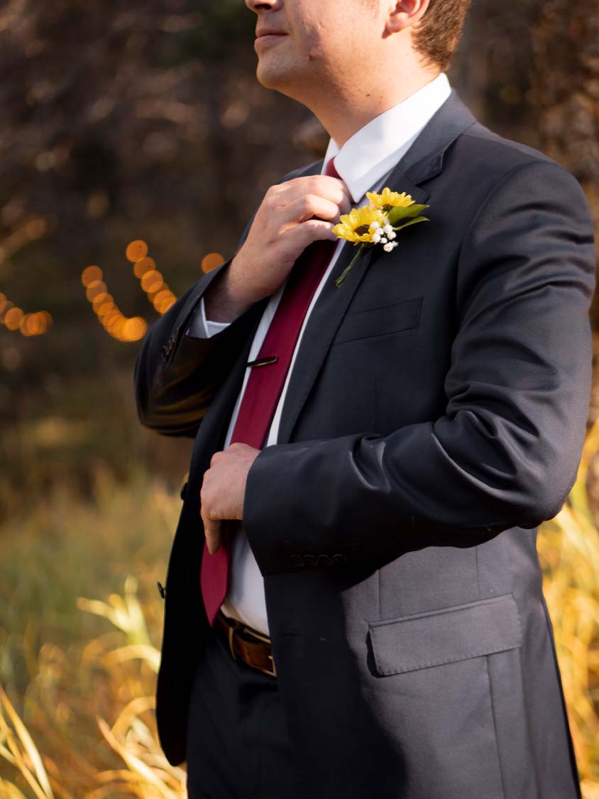 groom adjusting tie fall colors